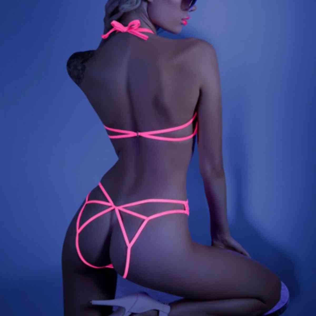 Frau in sexy neon-pinkem Spitzenbody Ouvert von hinten